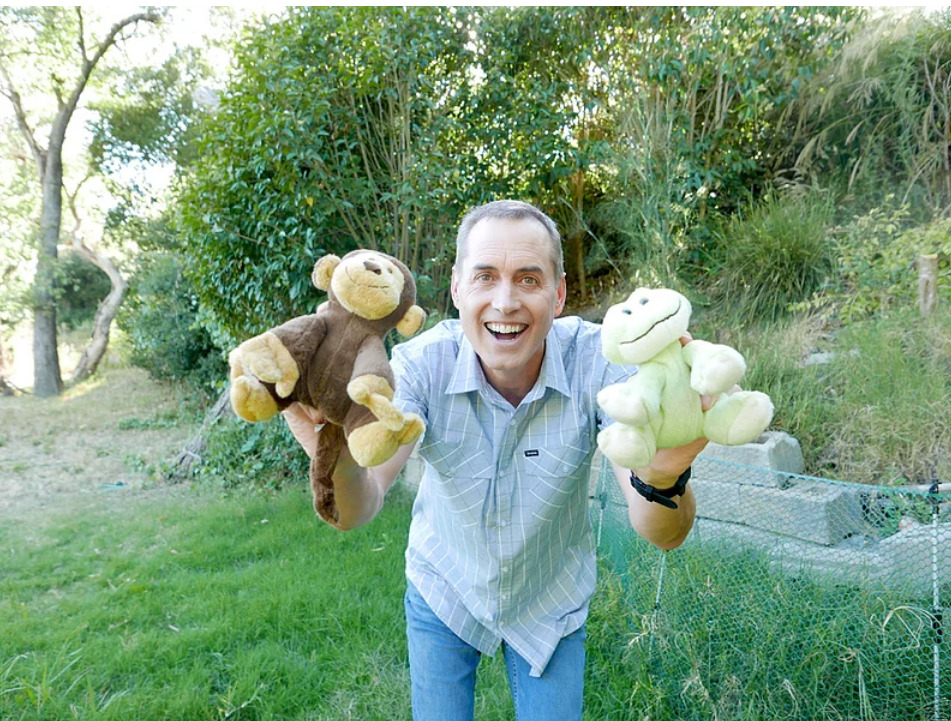 BJ Fogg smiling with two stuffed animals